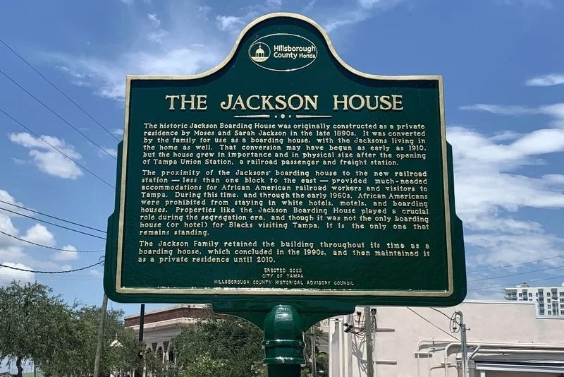 Green and gold Jackson House historical marker from the City of Tampa and Hillsborough County Historical Advisory Council, describing the boarding house's role during segregation
